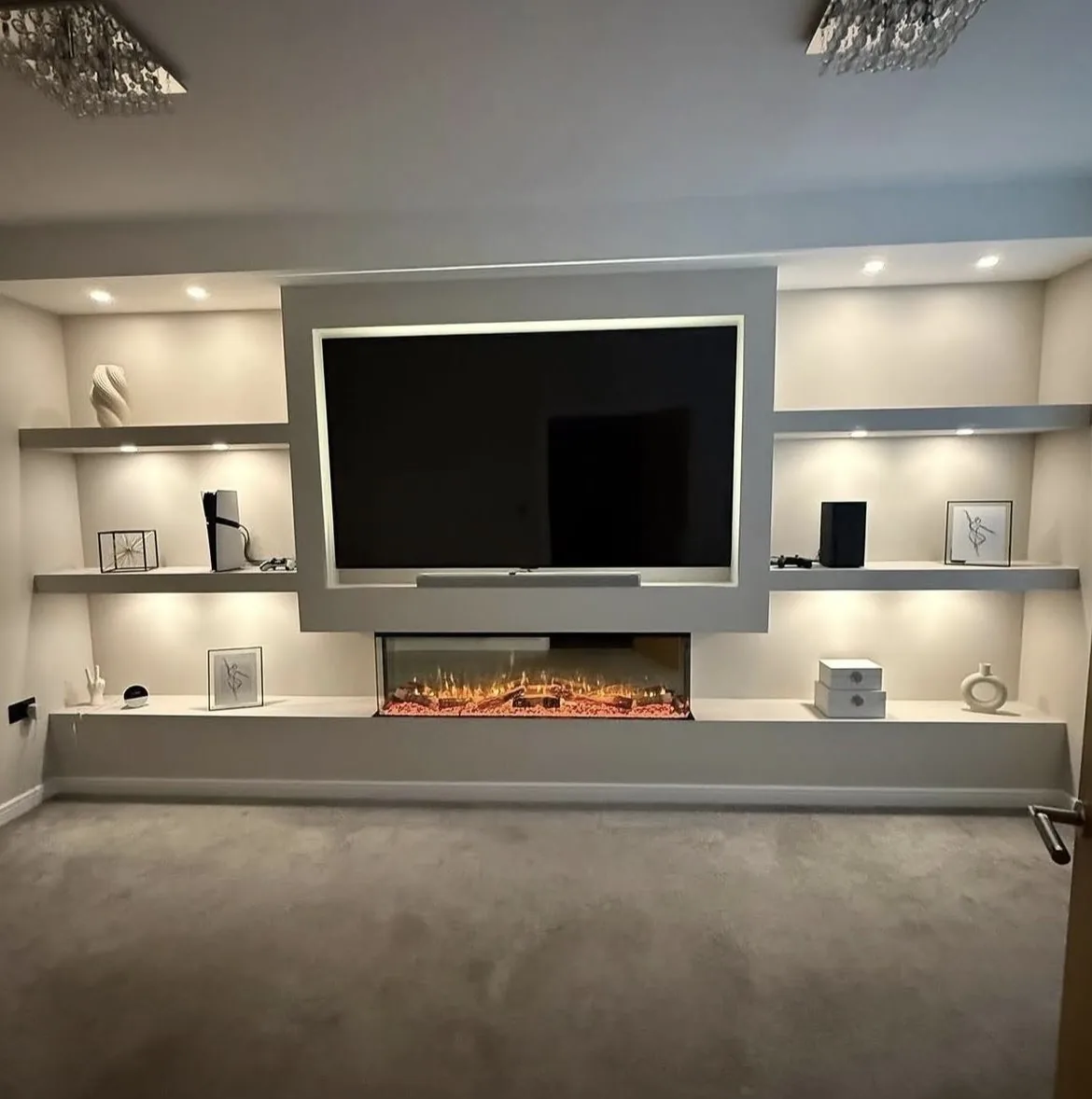Finished bespoke media wall with recessed TV, floating shelves and built-in fireplace