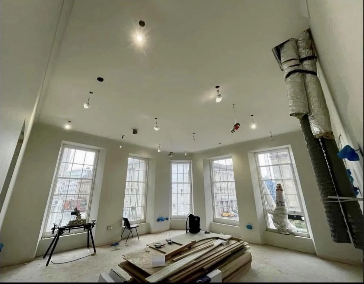Large bay-windowed lounge with newly plastered walls and downlit ceiling